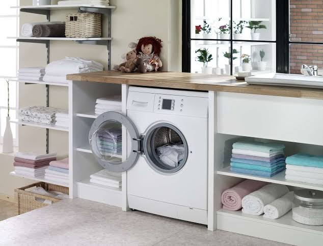 A Laundry Room Countertop with Washing Machine and Cabinets